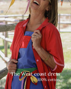 Woman laughing in a red dress in a garden